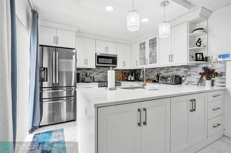 Whip up your favorites in this modern kitchen features sleek stainless steel appliances, including Samsung Range and Refrigerator with a French door design, and a stylish tile backsplash that blends function with flair!