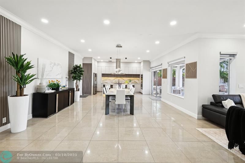 This elegant dining area seamlessly blends with the open-concept kitchen and living space, creating a perfect setting for both entertaining and everyday gatherings. Featuring polished marble-look flooring, recessed lighting, and modern finishes, the space feels bright, airy, and sophisticated. The current setup seats eight comfortably, with plenty of room to accommodate an even larger dining table for hosting extended family or dinner parties in style.