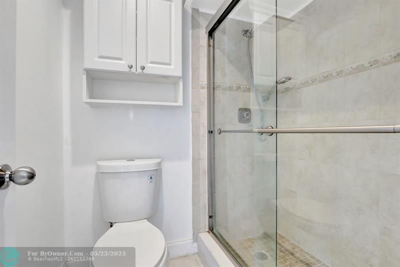 SHOWER WITH GLASS DOORS IN PRIMARY BATHROOM