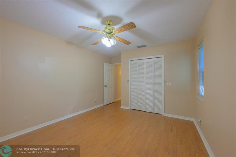 Two secondary bedrooms share a full hall bath with a makeup area, shower/tub combo, and matching Corian countertops.