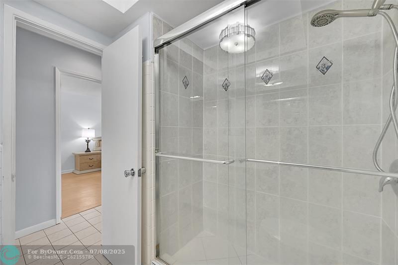 Your Bathroom Has an Updated Glass Enclosed Shower, Huge Custom Mirror, Built-In Hamper, Wall Heater and lots of Storage Cabinets and Countertops.