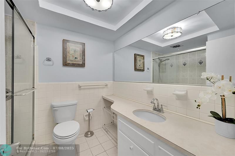 Your Bathroom Has an Updated Glass Enclosed Shower, Huge Custom Mirror, Built-In Hamper, Wall Heater and lots of Storage Cabinets and Countertops.