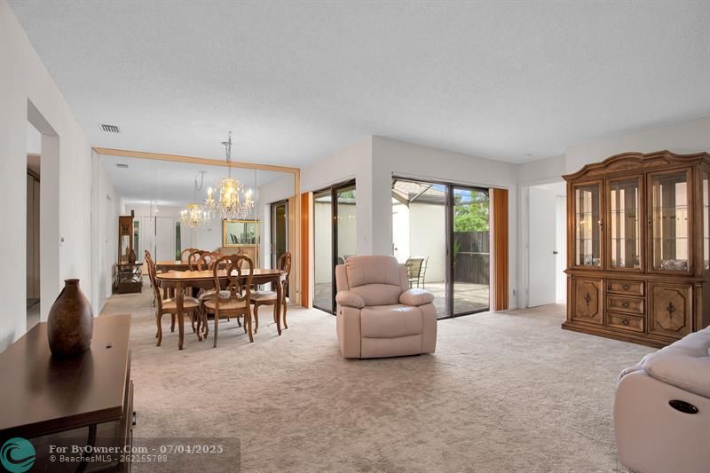 LIVING/DINING AREA WITH 2 SETS OF SLIDING DOORS TO YOUR PRIVATE SCREENED-IN PATIO